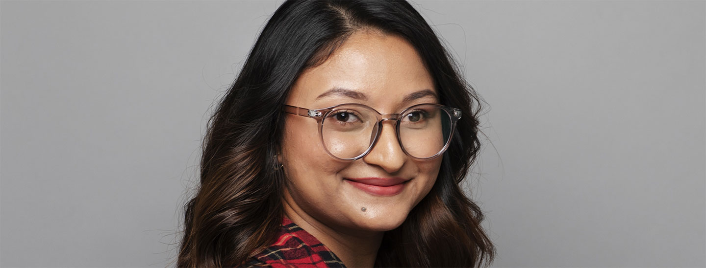 Female student wearing glasses grey background