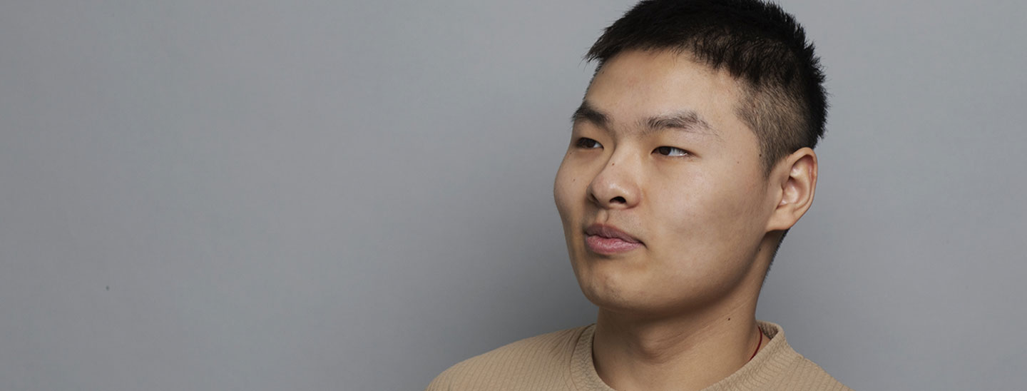 Male student on campus grey background