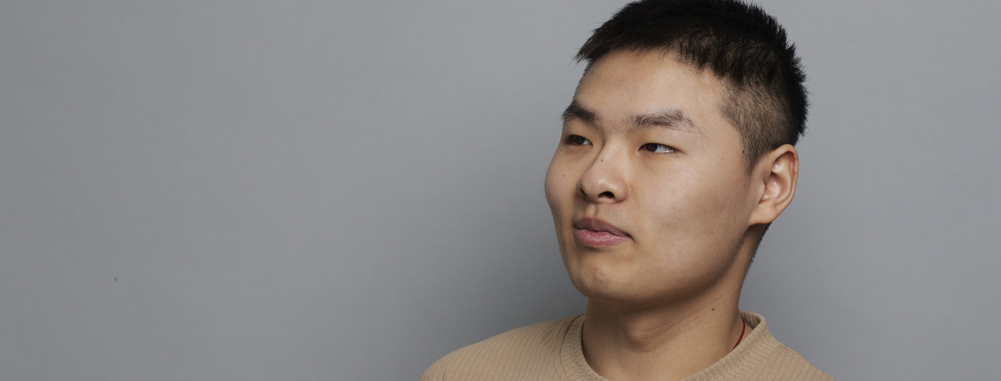 Male student on campus grey background